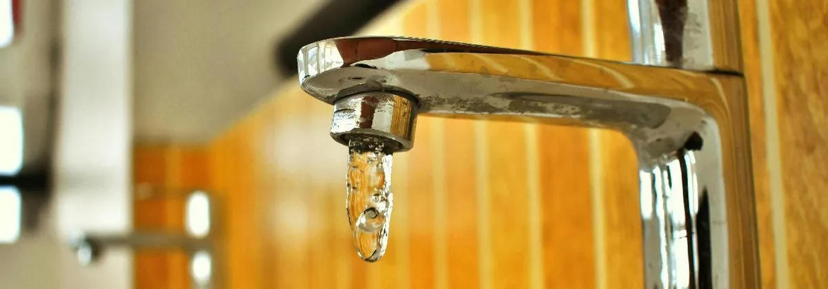 Water dripping from a chrome kitchen faucet