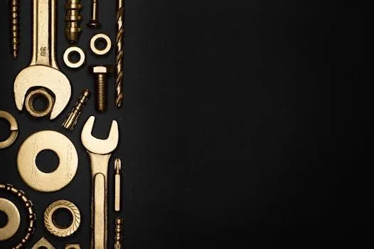 Brass wrenches, nuts, bolts, and drill bits arranged on a black background
