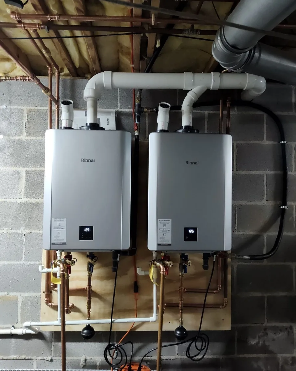 Two Rinnai tankless water heaters with connected plumbing, installed by Williams Plumbing Services